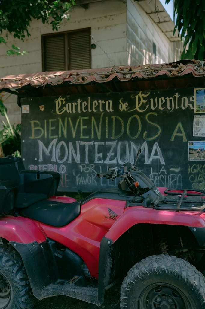 Welcome sign and a red ATV in Montezuma town, Costa Rica