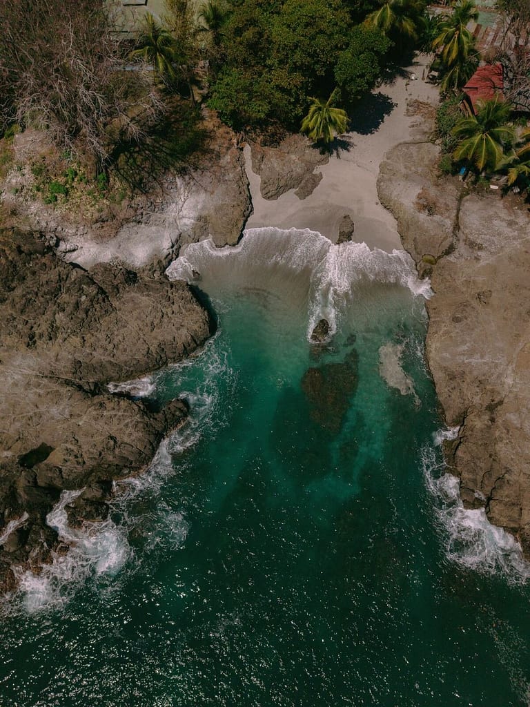 Aerial view of a rocky cove with turquoise water near Montezuma, Costa Rica
