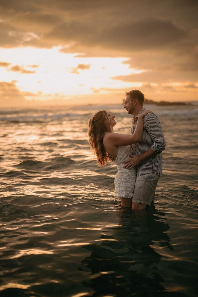 Bride and groom embracing in the ocean at sunset, Hotel Nantipa, Santa Teresa, Costa Rica