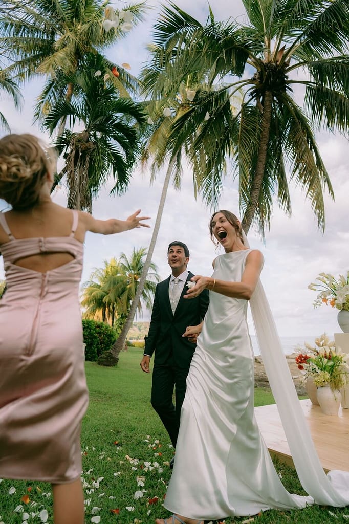 Bride and groom walking up the aisle under palm trees after their ceremony near Montezuma, Costa Rica