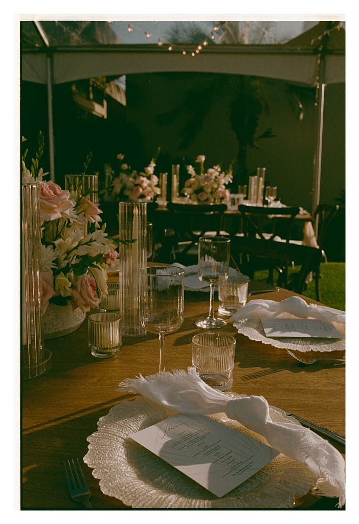 Film close-up of a reception place setting with a menu card on a lace-edged plate