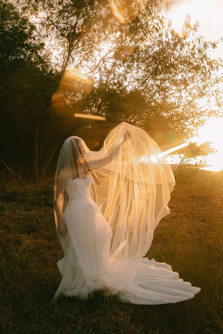 Bride lifting her veil in golden backlight at sunset, Tamarindo wedding, Costa Rica