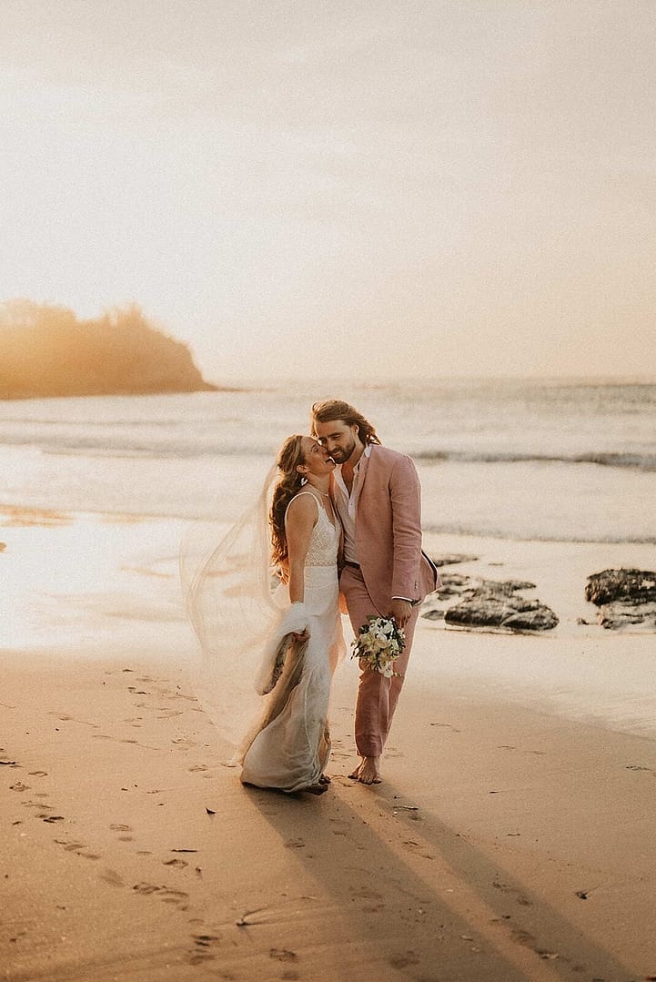 Bride and groom embracing on a Tamarindo beach at golden hour, Costa Rica beach wedding