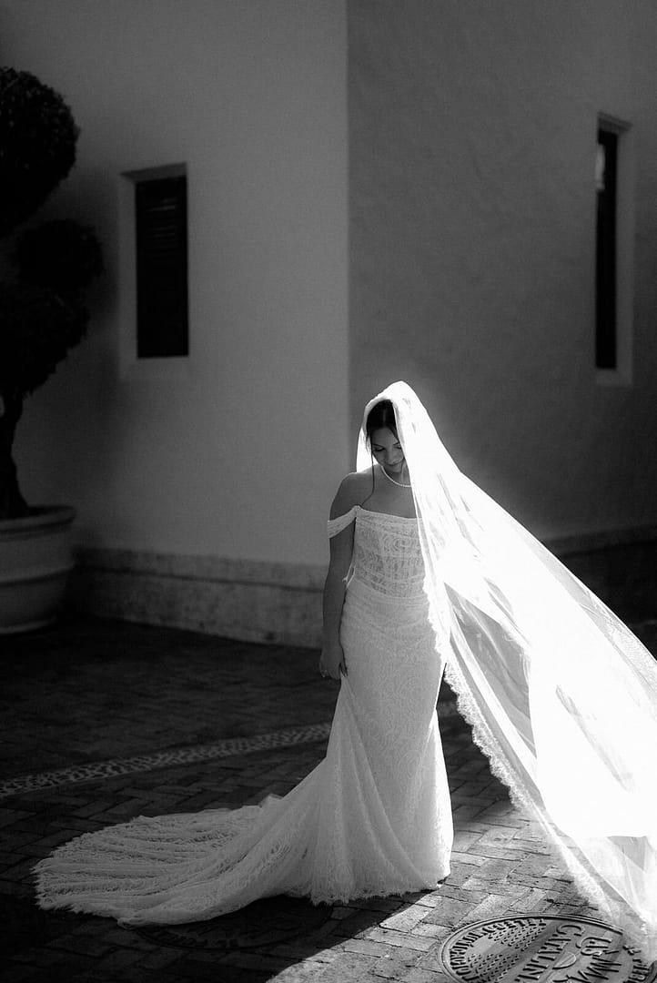 Black and white portrait of a bride in a long cathedral veil in a sunlit courtyard, Las Catalinas, Costa Rica