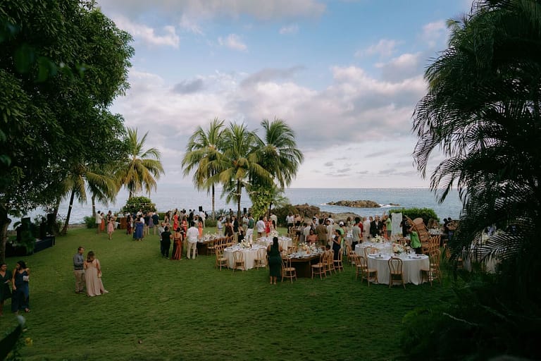 Outdoor wedding reception on an oceanfront lawn framed by palm trees, Costa Rica